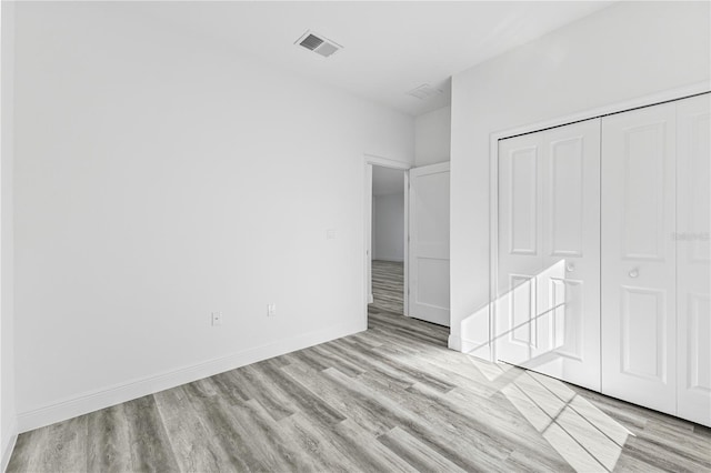 unfurnished bedroom with light hardwood / wood-style floors and a closet