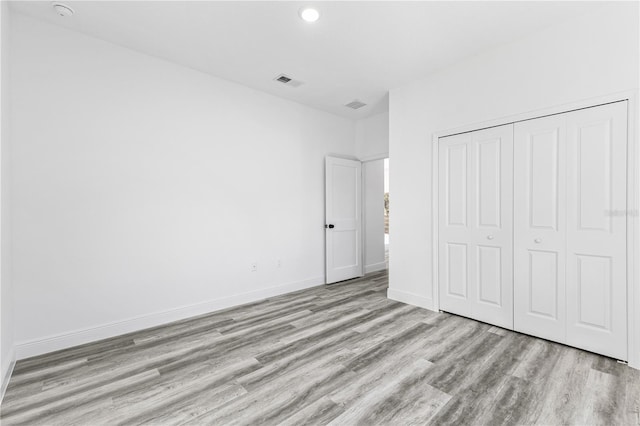 unfurnished bedroom featuring light hardwood / wood-style floors and a closet