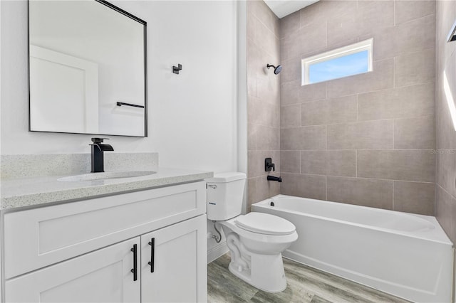 full bathroom with hardwood / wood-style flooring, vanity, toilet, and tiled shower / bath combo