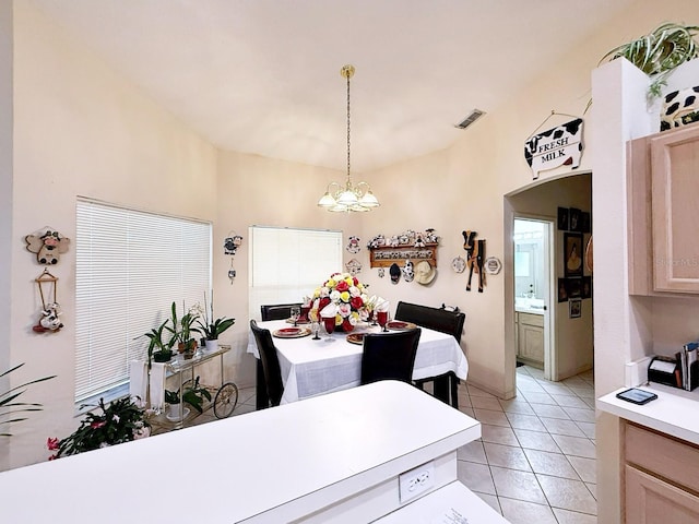 tiled dining area with a chandelier