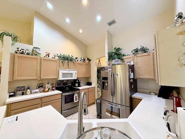 kitchen featuring stainless steel appliances, sink, vaulted ceiling, and light brown cabinets