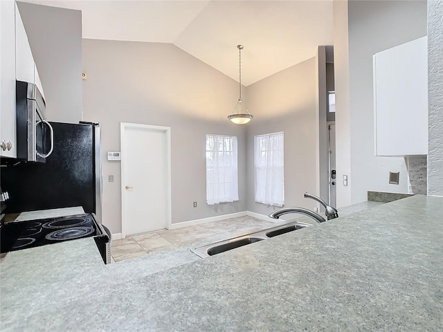 kitchen featuring sink, white cabinets, hanging light fixtures, stove, and light tile patterned floors