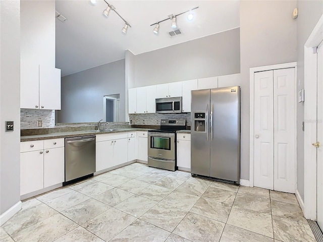 kitchen featuring tasteful backsplash, white cabinetry, appliances with stainless steel finishes, and sink