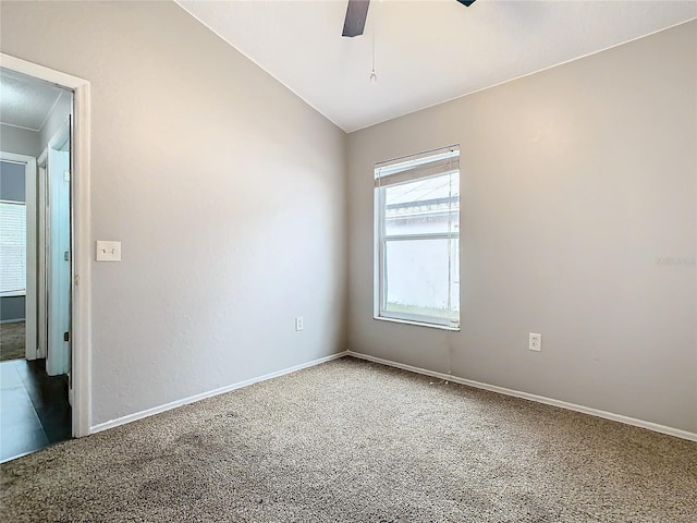 empty room featuring lofted ceiling, ceiling fan, and carpet flooring