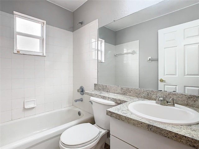 full bathroom featuring tiled shower / bath combo, vanity, and toilet