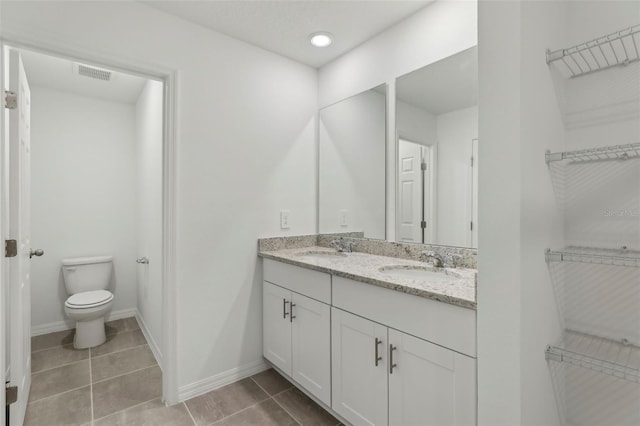 bathroom featuring vanity, toilet, and tile patterned flooring