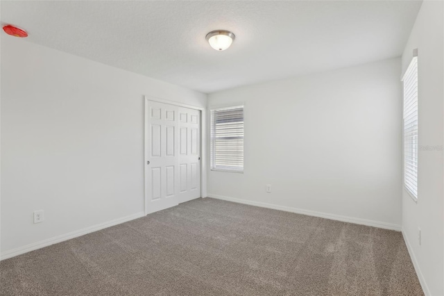 carpeted spare room with a textured ceiling