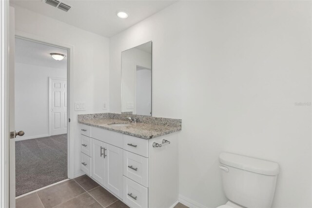 bathroom featuring vanity, toilet, and tile patterned flooring