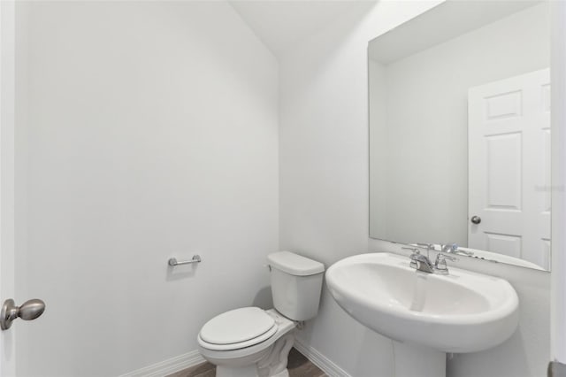 bathroom featuring sink, wood-type flooring, and toilet