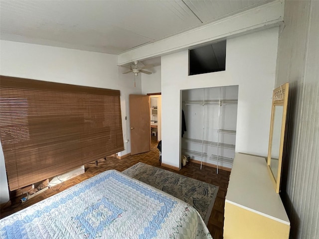 bedroom with beamed ceiling, parquet flooring, a closet, and a towering ceiling