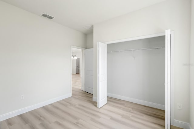 unfurnished bedroom featuring light hardwood / wood-style floors and a closet