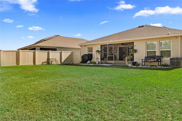 rear view of house featuring ceiling fan, a yard, and central air condition unit