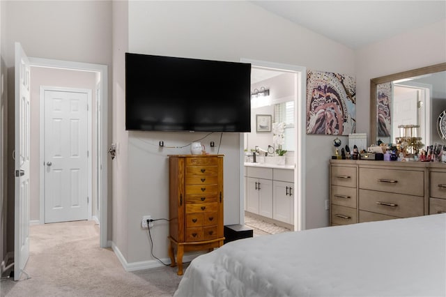 carpeted bedroom featuring ensuite bathroom and vaulted ceiling