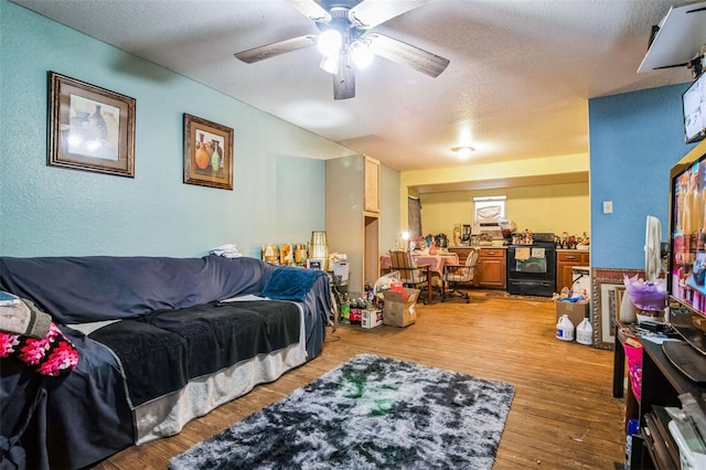 bedroom featuring ceiling fan, wood-type flooring, and a textured ceiling