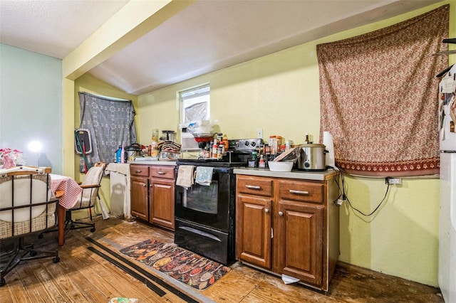 kitchen featuring dark hardwood / wood-style floors, black electric range, and vaulted ceiling with beams