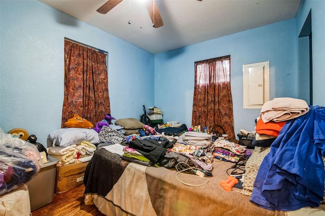 bedroom featuring wood-type flooring, electric panel, and ceiling fan