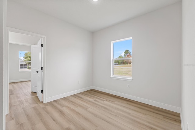 unfurnished room featuring a wealth of natural light and light hardwood / wood-style floors