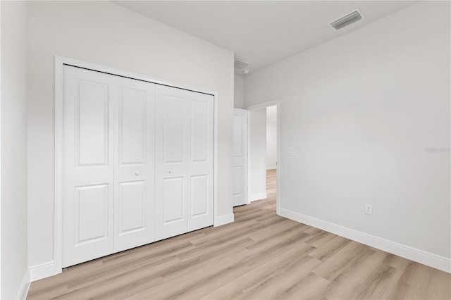 unfurnished bedroom with a closet and light hardwood / wood-style flooring