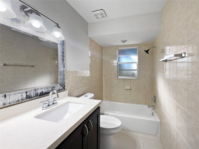 full bathroom with tile patterned floors, toilet, tile walls, vanity, and tiled shower / bath combo