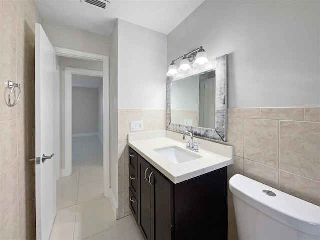 bathroom with vanity, tile walls, tile patterned floors, and toilet