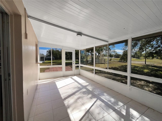 unfurnished sunroom featuring vaulted ceiling and wooden ceiling