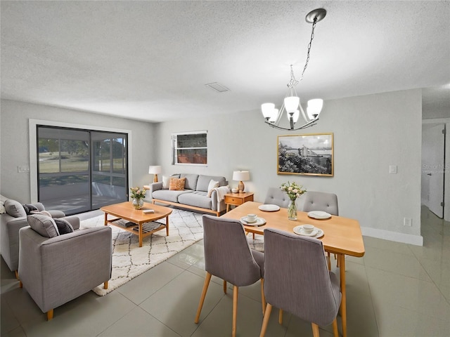 tiled dining space featuring a chandelier and a textured ceiling