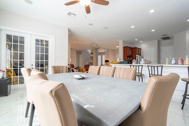 dining area featuring a textured ceiling, french doors, and ceiling fan