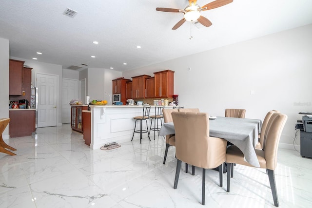 dining room featuring a textured ceiling and ceiling fan