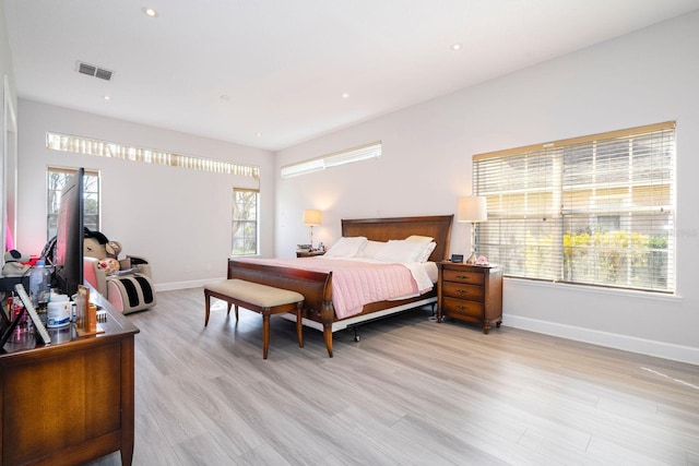 bedroom featuring multiple windows and light hardwood / wood-style flooring