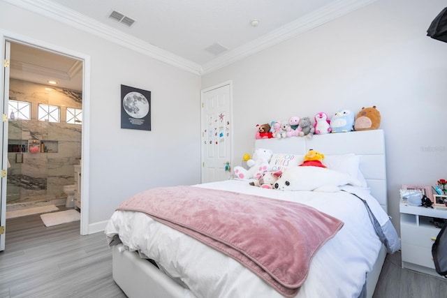 bedroom with crown molding, wood-type flooring, and ensuite bath