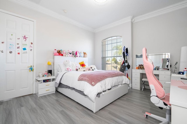 bedroom featuring crown molding and light hardwood / wood-style flooring