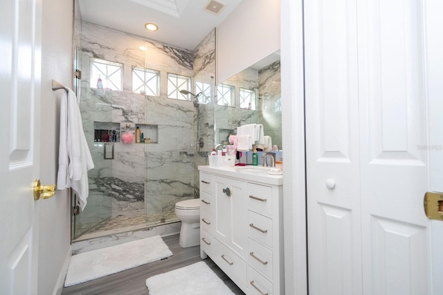 bathroom with walk in shower, vanity, toilet, and wood-type flooring