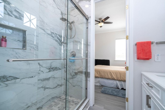 bathroom featuring walk in shower, ceiling fan, ornamental molding, and vanity