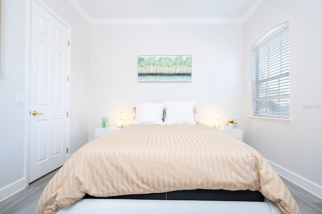 bedroom with crown molding and hardwood / wood-style floors