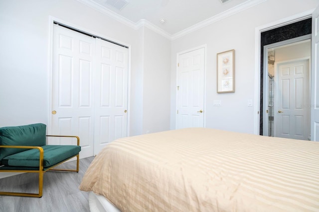 bedroom with crown molding, a closet, and hardwood / wood-style flooring