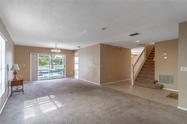 unfurnished living room featuring a textured ceiling, light carpet, and a notable chandelier