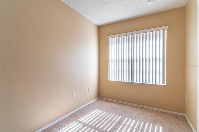 carpeted empty room with plenty of natural light and a textured ceiling