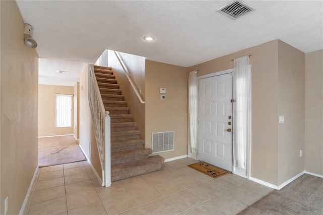 tiled entryway featuring a textured ceiling