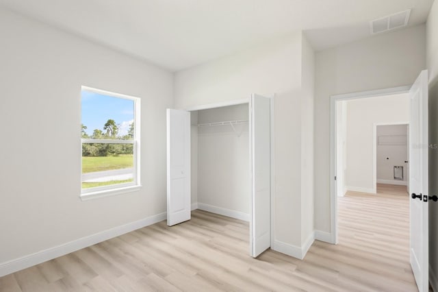 unfurnished bedroom with light hardwood / wood-style flooring and a closet