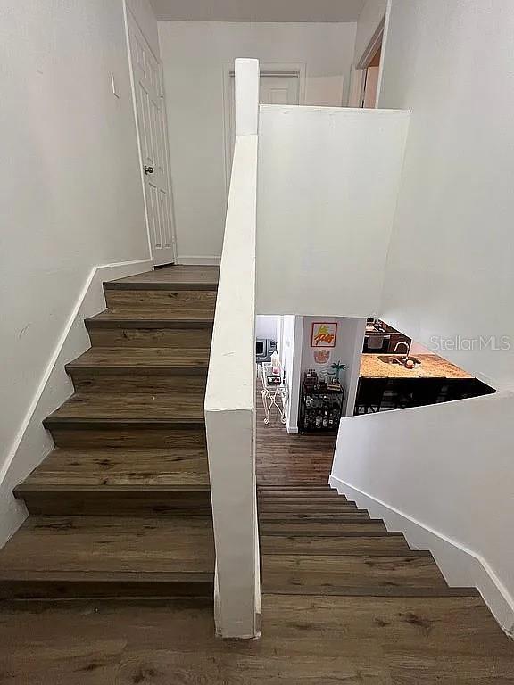 stairs featuring hardwood / wood-style floors