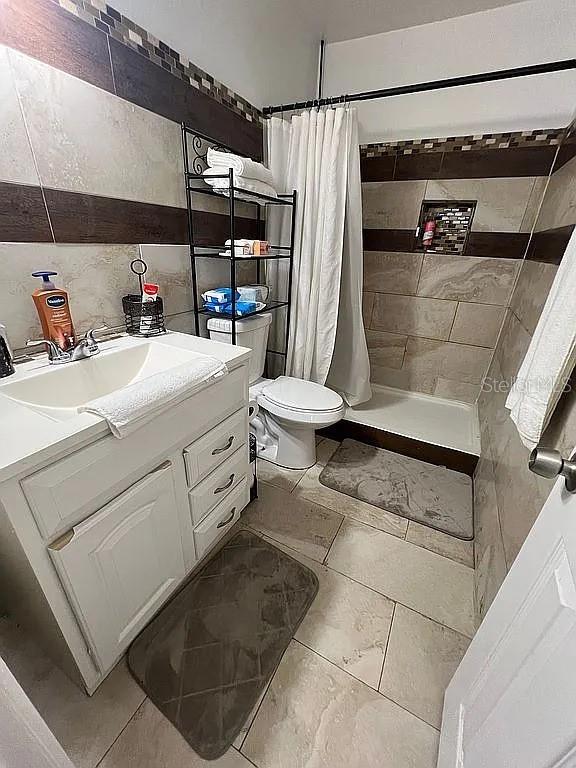 bathroom featuring vanity, toilet, and a shower with shower curtain