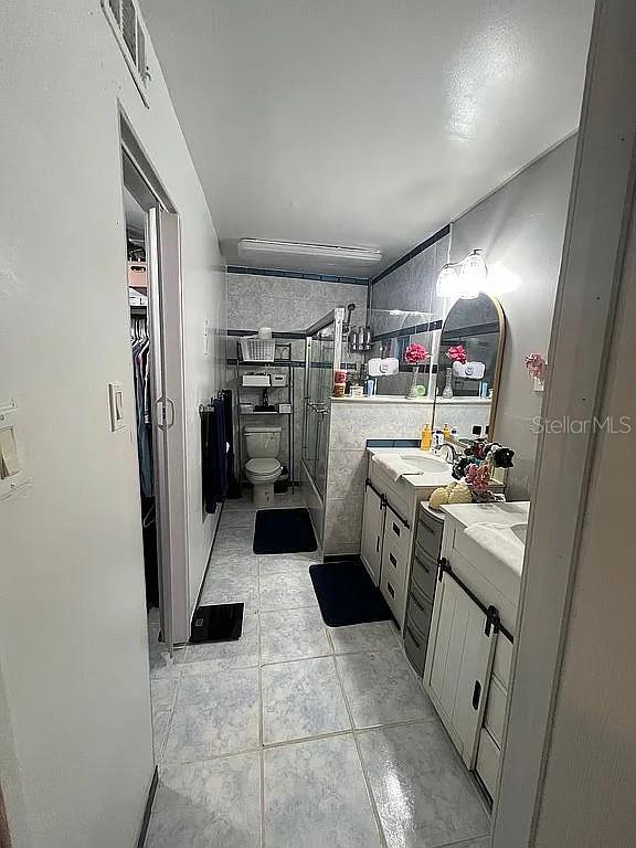 bathroom featuring vanity, tile patterned flooring, and toilet