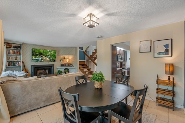 tiled dining area featuring a textured ceiling and wood walls