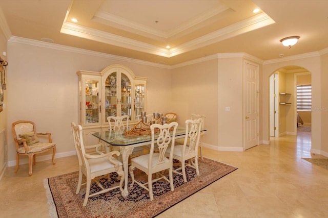 dining area featuring a tray ceiling and ornamental molding