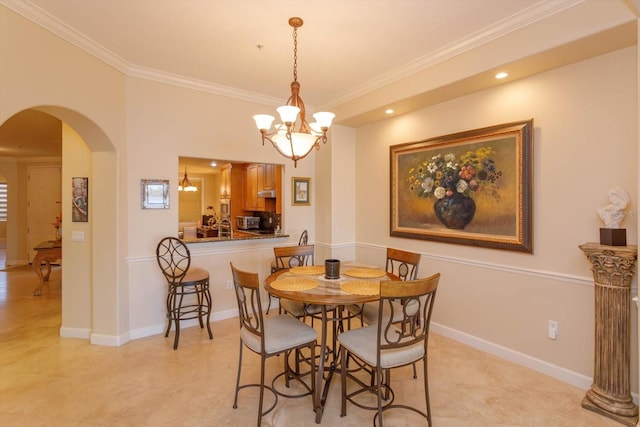 dining room with ornamental molding and a notable chandelier