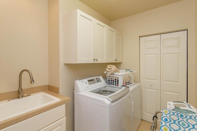 laundry room with independent washer and dryer, cabinets, sink, and light tile patterned floors