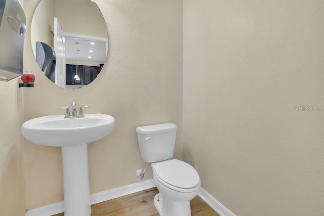 bathroom featuring wood-type flooring, toilet, and sink