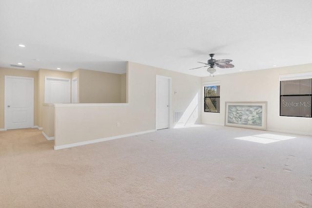 unfurnished living room featuring ceiling fan and light colored carpet