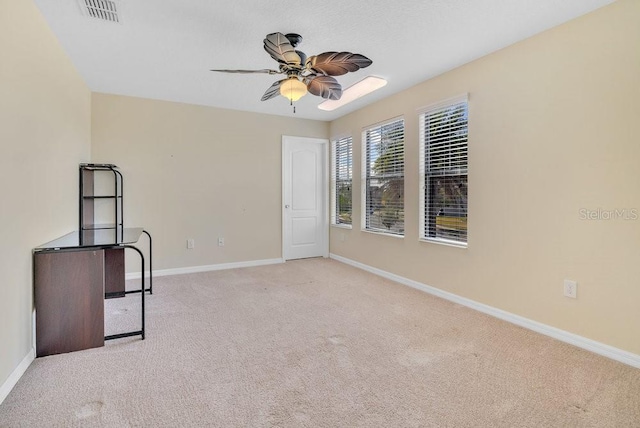 carpeted spare room featuring ceiling fan