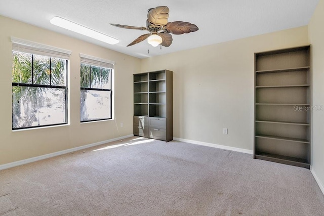 unfurnished room with ceiling fan and light carpet